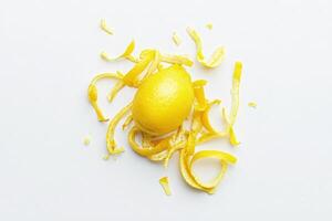 Bright yellow lemon zest is beautifully arranged with fresh peel scattered around it. This vibrant composition highlights the zests texture, ideal for enhancing dishes or drinks. photo