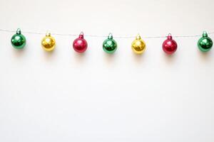Vibrant holiday garlands display an array of shiny ornaments in red, green, and gold, creating a festive atmosphere against a clean, minimalist background perfect for seasonal celebrations. photo