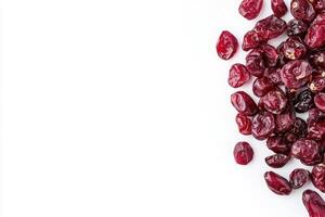 A collection of dried cranberries is displayed on a smooth, solid white surface, highlighting their deep red hue and wrinkled texture. These nutritious fruit snacks are perfect for various dishes. photo