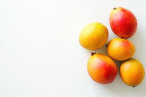 A group of exotic mangoes showcases a mix of yellow and red hues against a clean white background, emphasizing their juicy appeal and freshness perfect for culinary use. photo