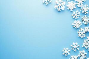 Delicate white snowflakes are artfully arranged on a smooth blue background, creating a festive atmosphere perfect for winter themes and holiday decorations. photo