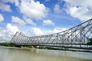 The historic Howrah bridge from Mullick Ghat in sunny weather photo