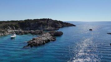 Drone View of Solitary Yacht Moored by Island in a Tranquil Bay on a Sunny Day video