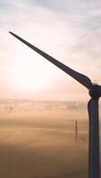 A wind turbine is seen in the distance at sunrise video