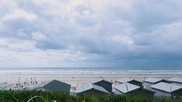 Beach huts on the beach with a cloudy sky video