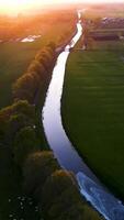 Aerial view of a river flowing through a field at sunset video