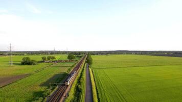 An aerial view of a train traveling through a green field video