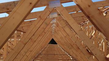 Wooden roof trusses on a construction site forming a tunnel-like effect with beams lined up in perfect symmetry video