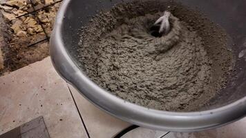 Close up of cement being mixed in a bucket, related to construction and DIY projects video