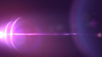 A purple light is shining on a dark background and lens flares video