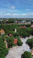 Cinematic movement to a large white seated Buddha statue amidst the riverside scenery of Wat Ko Kaew. video