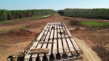 Construction team in hard hats work at the construction site aerial shot. Concrete structure. Builders in the process of work. Construction of an overpass and a bridge video