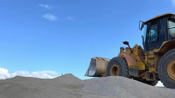 Wheel loader with a bucket in front. Side view. Heavy machinery is working on the construction site. Tractor shovels sand and gravel with a bucket. Turkey, Mersin. August 29, 2023 video