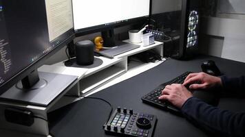 European man using ergonomic workplace equipment for login and using apps in two monitors setup to work from home office or as freelancer with modern technology setup and special devices for streaming video