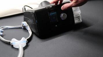 Male European with cpap machine checking therapy analysis via smartphone app or medical app for e health check and health report via mobile device for health analysis innovative sleep apnea mask apps video