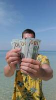 Man counting US dollars in the tropics. video