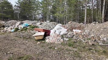 Discarded construction debris in a forest clearing highlights environmental pollution, waste management issues video
