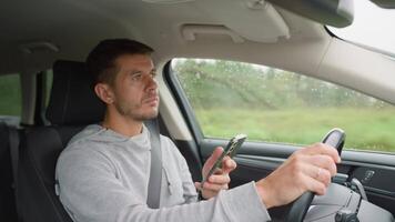 Driver using smartphone while driving car, distracted by messages on his phone. Dangerous driving of a vehicle, violation of traffic rules video