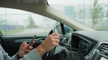 Driver using smartphone while driving car, distracted by messages on his phone. Dangerous driving of a vehicle, violation of traffic rules video