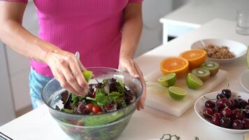 Unrecognizable female adding lime juice into salad in kitchen video