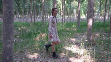 A woman cleverly hides behind a tree in a vibrant forest, creating a playful atmosphere video
