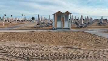 Beach Scene Featuring Lifeguard Tower Accompanied by Rows of Colorful Umbrellas video