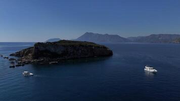 Aerial Drone View of Island with Mountain Backdrop and Moored White Yachts video