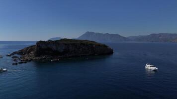 Drone View of Island with Mountainous Backdrop and Moored White Yachts video
