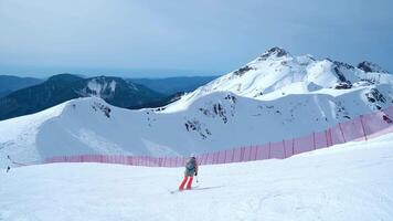 A Group Of Athletes On Skis And Snowboards Ride In The video
