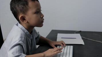 a child is learning about computers by typing on the keyboard on the table video