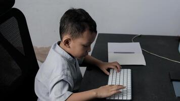 a child is learning about computers by typing on the keyboard on the table video