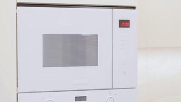 The girl opens the microwave oven by pressing the touch button. Modern technologies. A smart home. Warming up the food. video