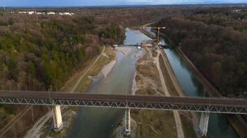 Grosshesseloher Brucke on Isar River in Munich, Germany aerial view. Two-story railroad and pedestrian bridge in Munchen over Isar River. Eisenbahnbrucke. Bike path runs under Railroad tracks. video