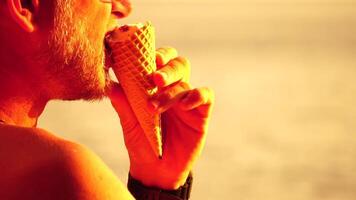 Man eating ice cream. Close-up portrait of young hipster man in sunglasses eating ice cream in summer hot weather on the beach, have fun and good mood. Travel, tourism, vacation, pleasure, enjoying. video