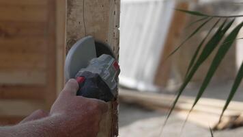A man is using a power tool to cut wood. Concept of productivity and hard work. Slow motion video