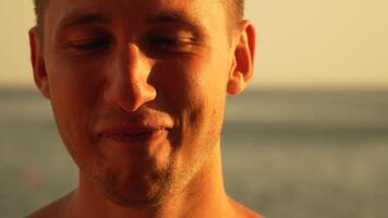 Man Smiling Beach Sunset - Closeup portrait of a man smiling at the beach during sunset. video