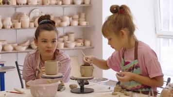 Mother and daughter create pottery together in a cozy studio setting video