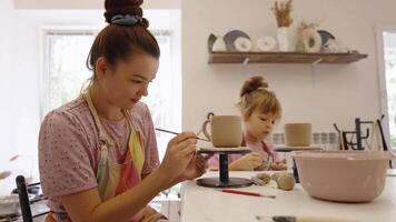 Creating pottery with a child in a cozy workshop on a sunny afternoon video