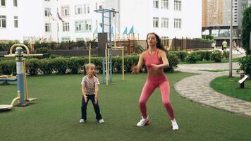 Mother and daughter working out together at a playground in the afternoon video