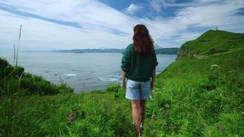 Young Brunette Woman In Denim Shorts Walking Alone In Beautiful Mountains With Sea View, Back View video
