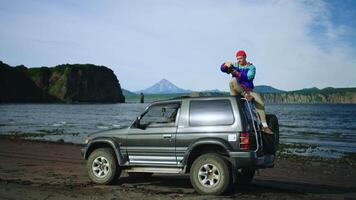 Adventure And Exploration In National Reserve, Tourist Sitting At Top Of SUV And Photographing video