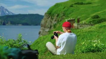 Young Male Photographer Relaxing At Top Of Mount And Photographing Ocean And Volcano video
