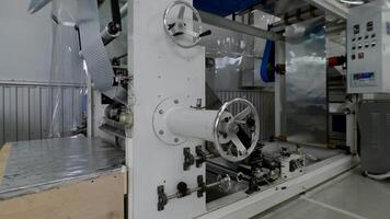 Massive apparatus designed for the fabrication of ultrathin metal sheets operates in an automated capacity within the confines of a manufacturing facility. video
