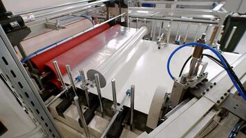 In manufacturing process of sturdy paper, large sheets are wrapped in cellophane for safe transport and then divided into smaller sections using circular saw. video