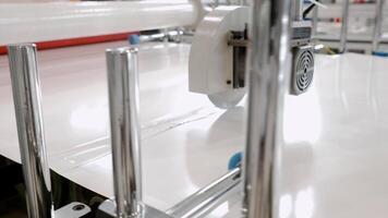 Sizable circular saw, operating in an automated mode on manufacturing line, efficiently dissects substantial sheet of rigid paper into components as it proceeds along conveyer. video