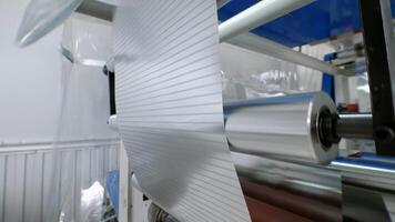 close-up of manufacturing process for sheet metal using machine tool. Sheet of foil is transported along conveyor belt in factory. video