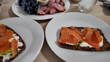 Plates of smoked salmon on rye bread with cream cheese and avocado, perfect for brunch or Easter video