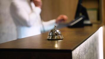 Guest ringing service bell at front desk, waiting to receive assistance from hotel staff at reception counter video