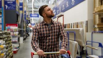 Customer walking with shopping cart in hardware store video