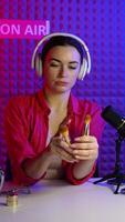 Woman beauty blogger streaming a vlog from studio and showing new brushes. Vertical video